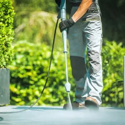 Professional pressure washing on a residential surface in Dunedin, showing safe and compliant exterior cleaning methods.