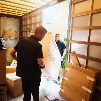 Team loading household items into a truck during a rubbish removal job in Dunedin.