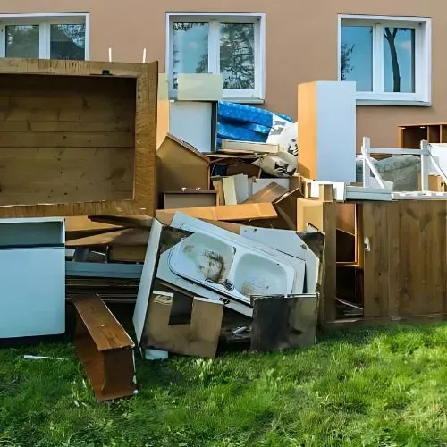 A North Dunedin flat with household and whiteware junk on the front lawn before rubbish clearance and removal services.