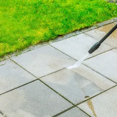 Using controlled pressure washing on pavers to minimise water use and comply with Dunedin residential restrictions.