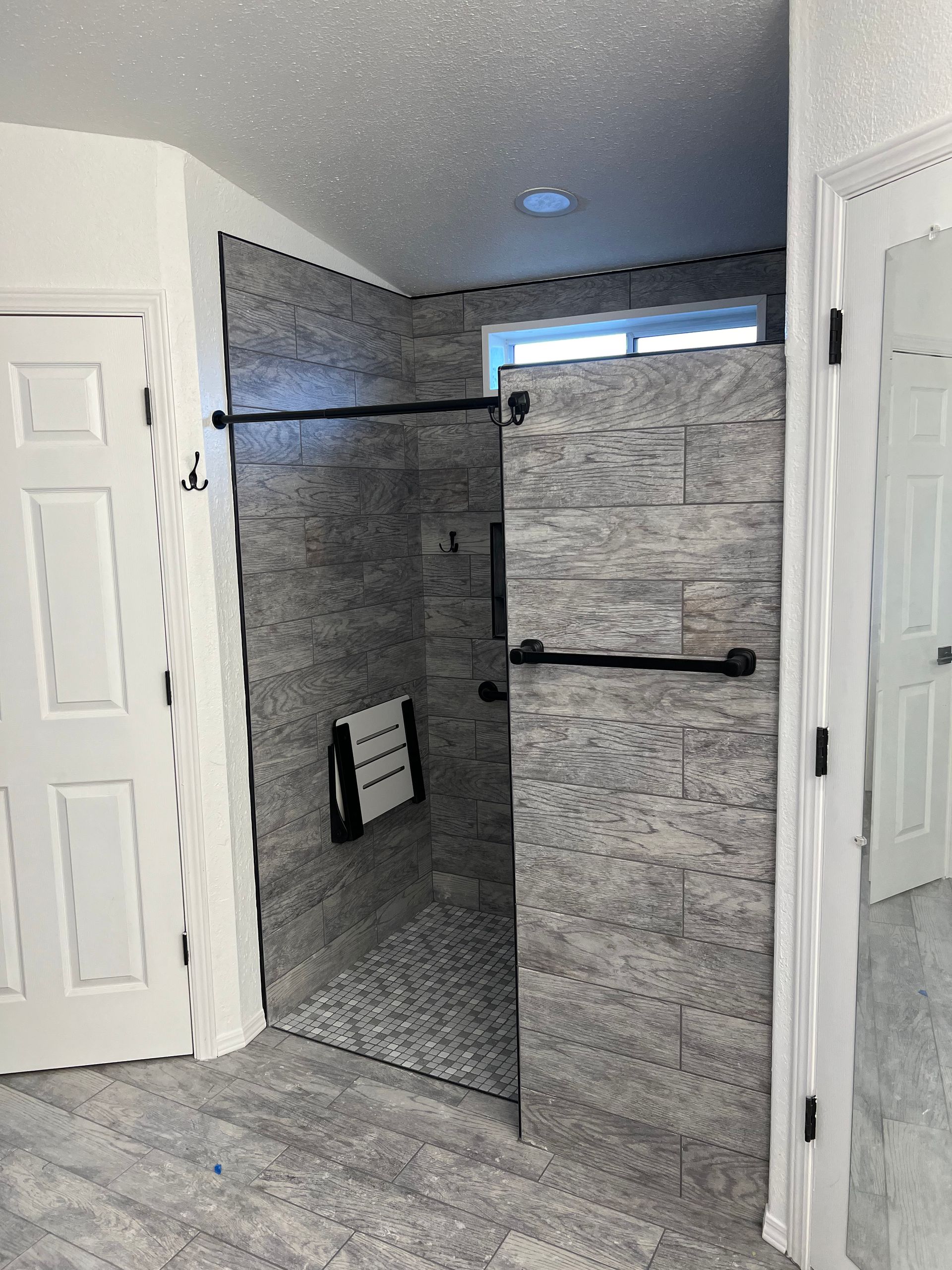 A bathroom with a walk in shower and a mirror.