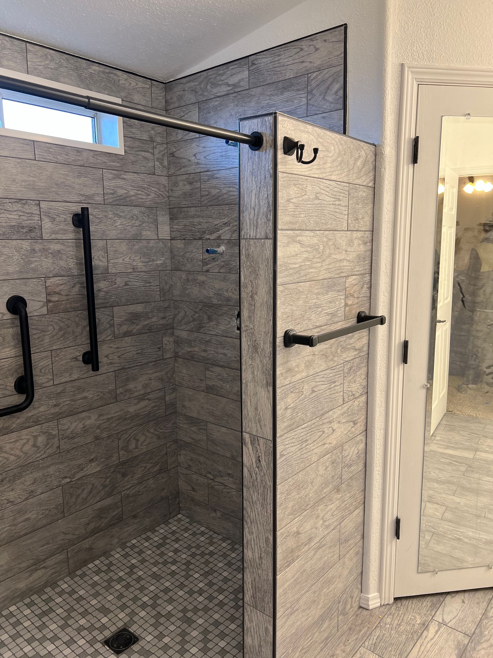 A bathroom with a walk in shower and a mirror.