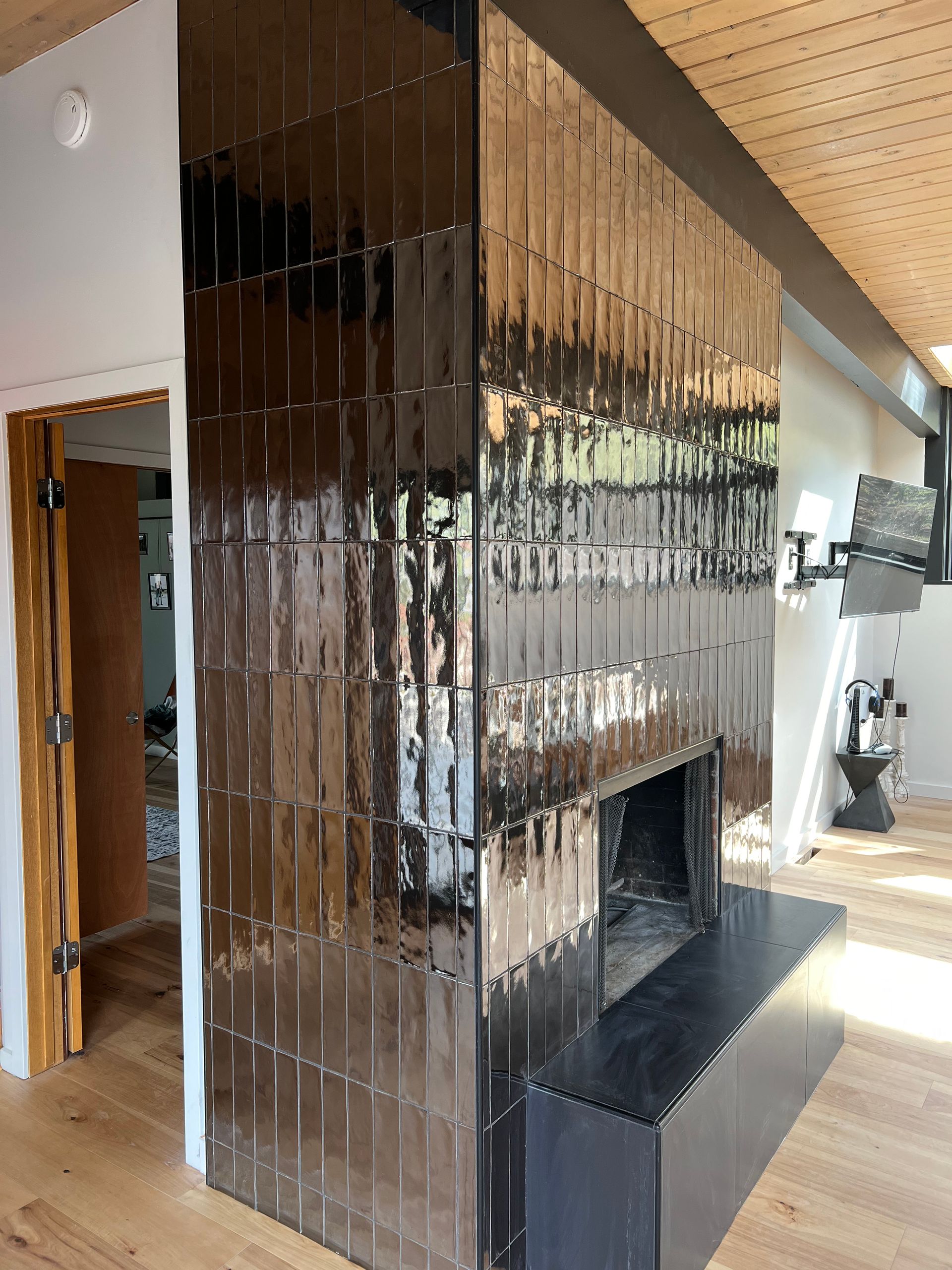 A living room with a fireplace and a mirrored wall