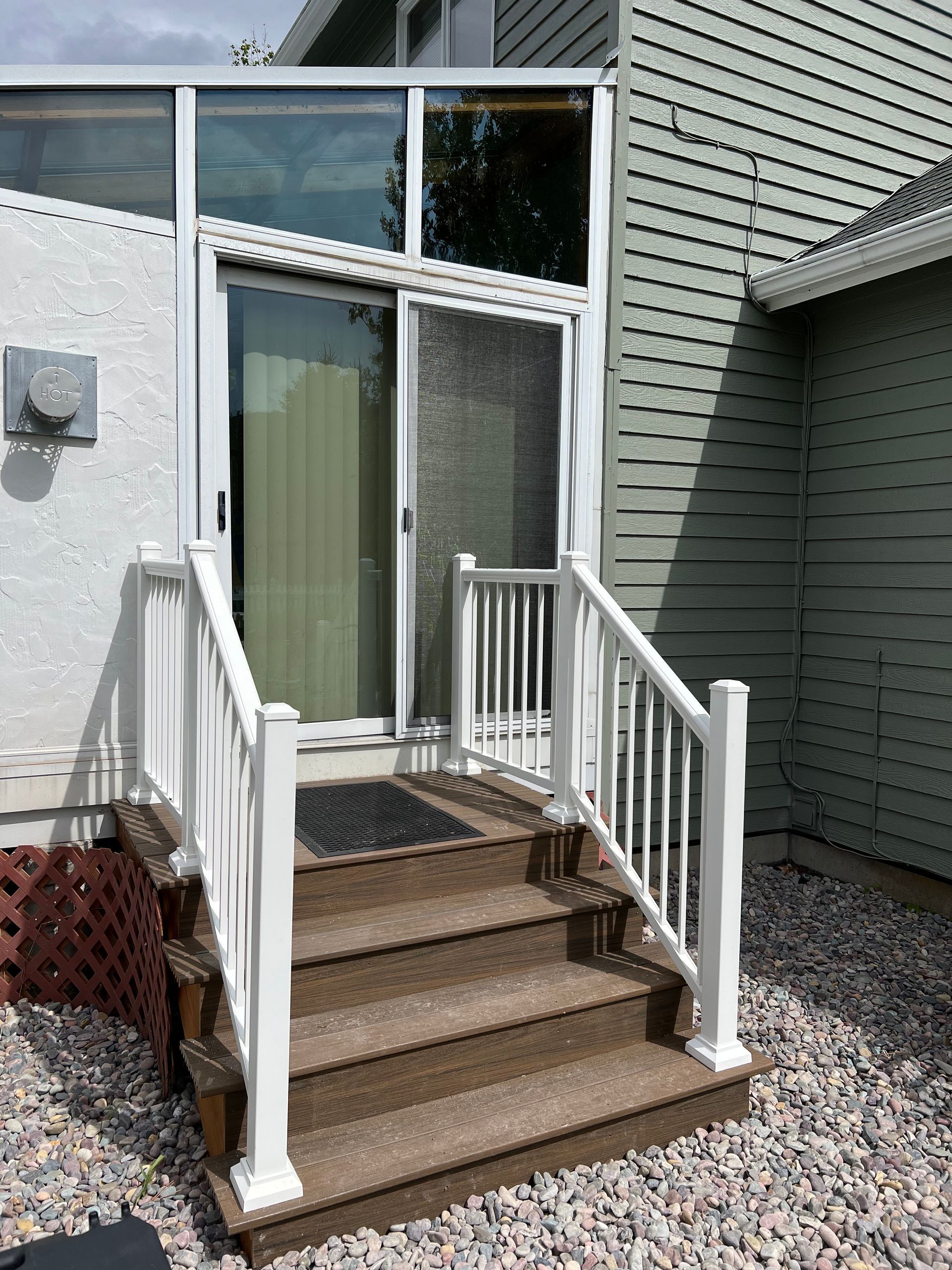 A house with a sliding glass door and stairs leading up to it