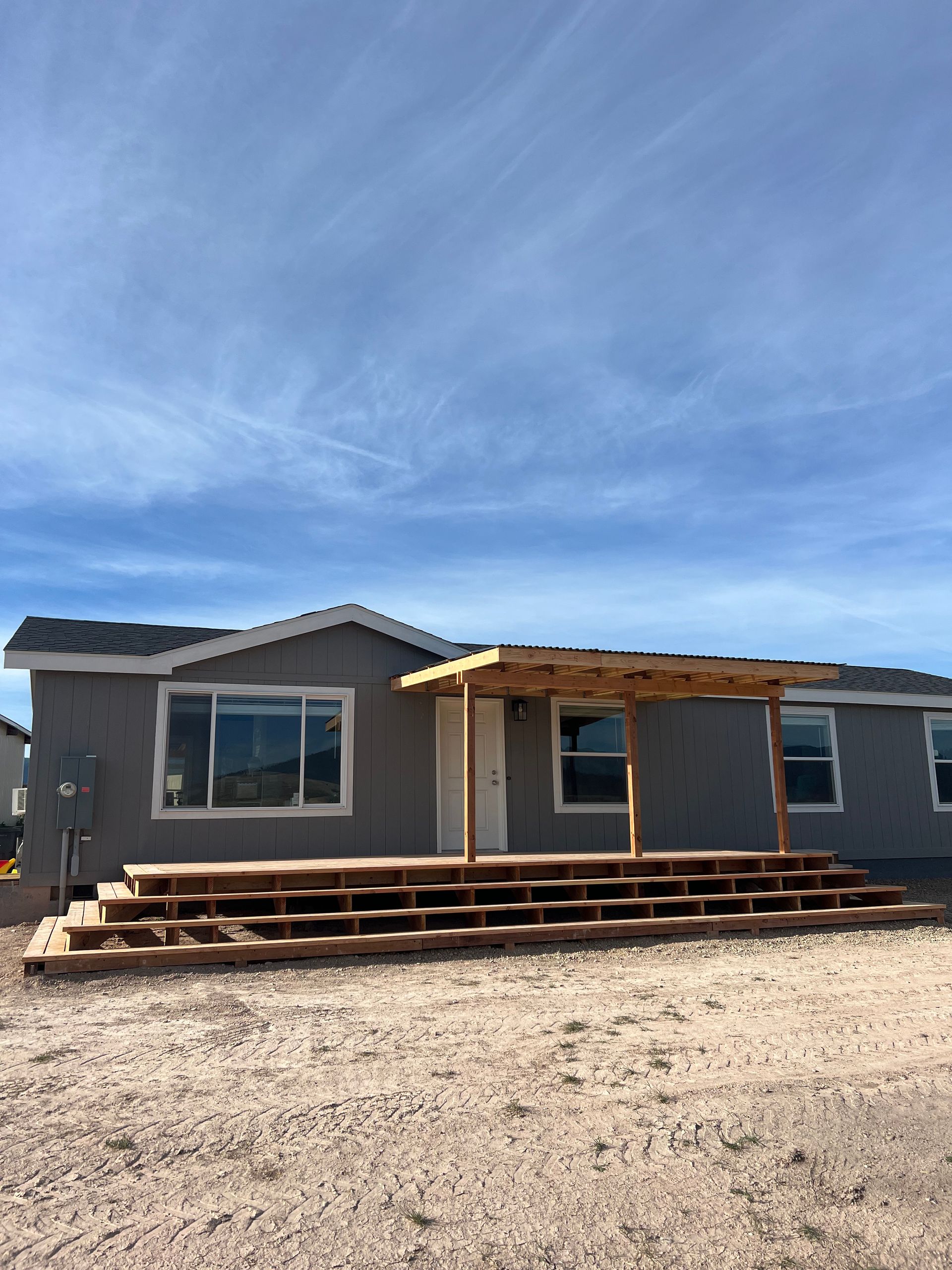 A mobile home with a porch and stairs in front of it