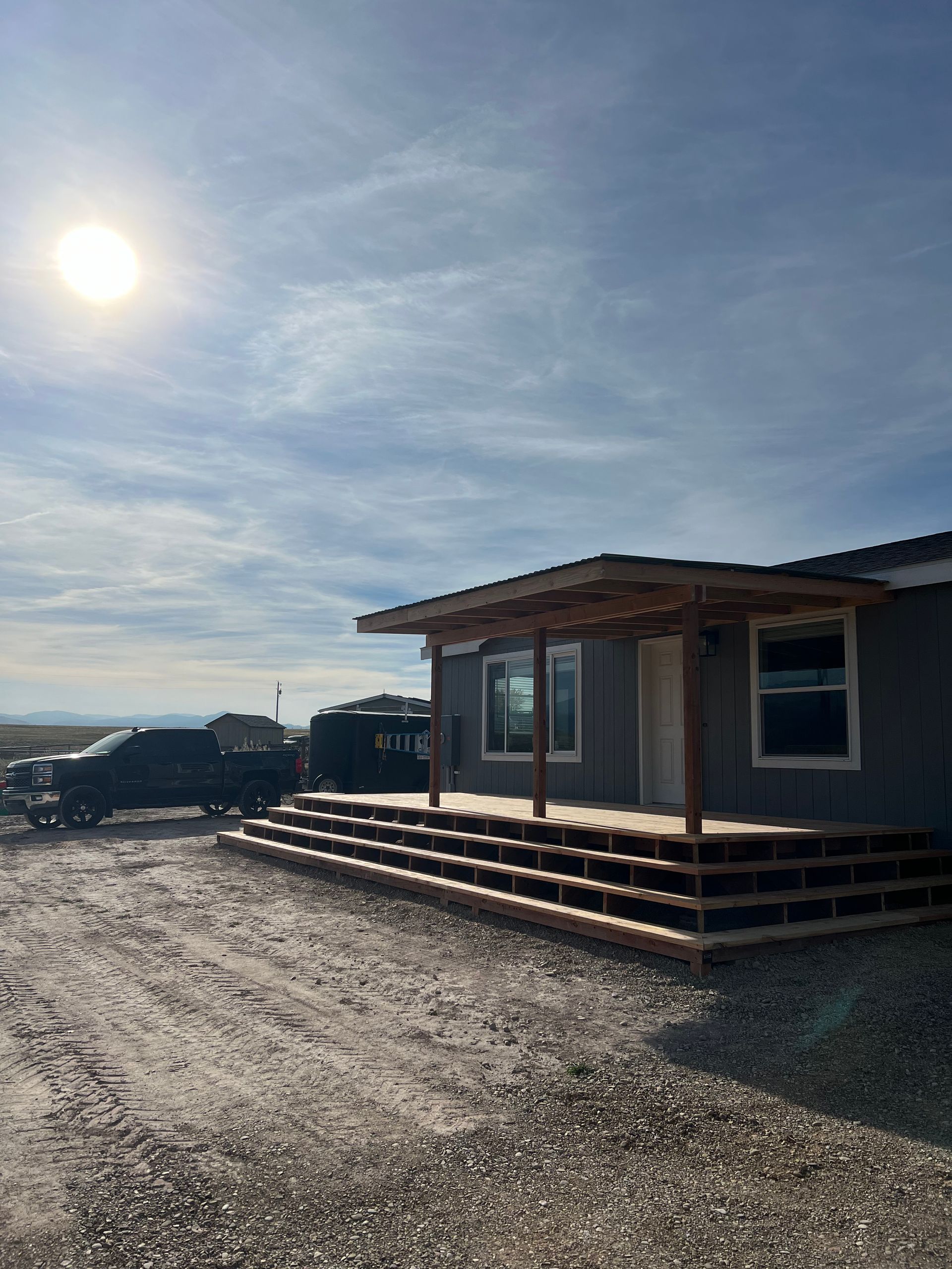 A house with a porch and a truck parked in front of it