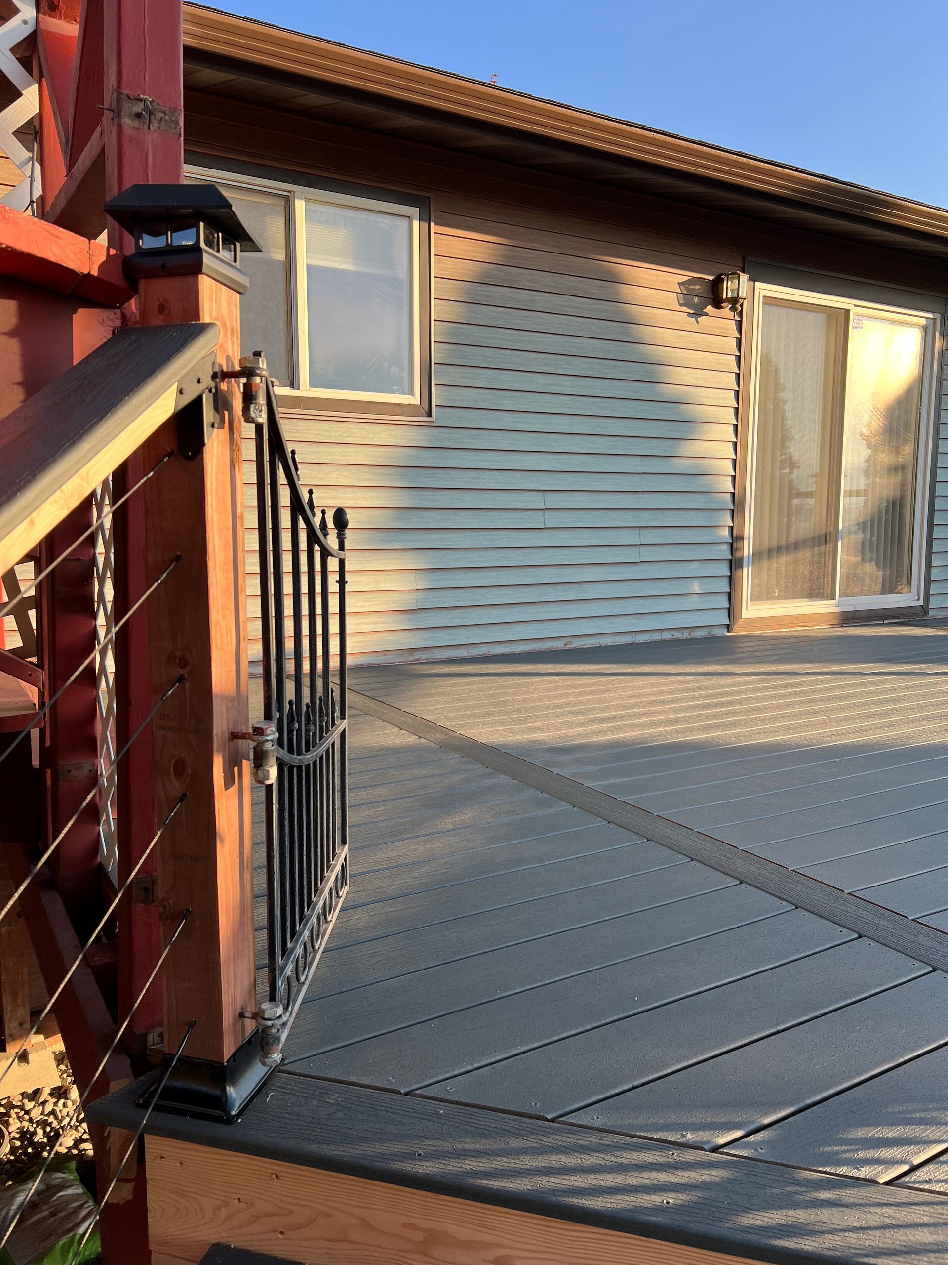 A deck in front of a house with a sliding glass door