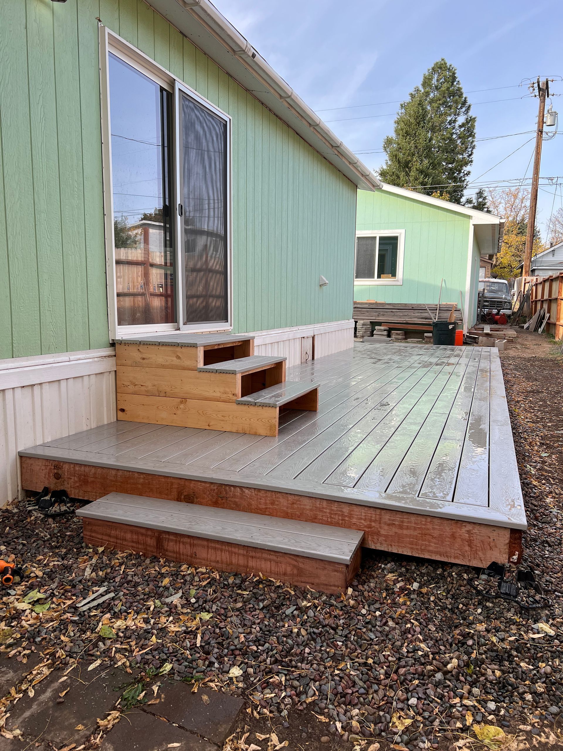 A mobile home with a deck and stairs in front of it