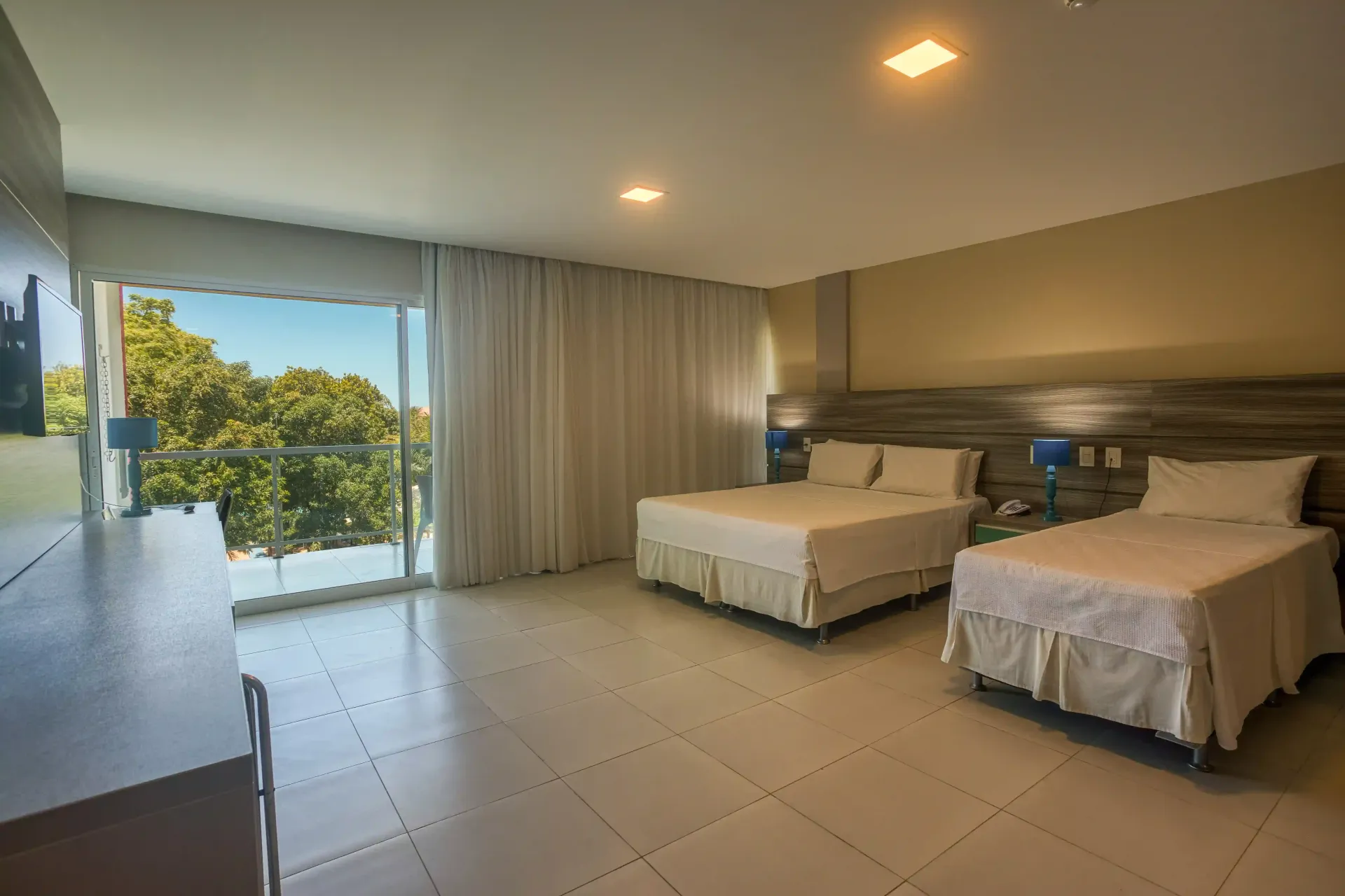 Um quarto de hotel com duas camas e uma varanda.-hotel-praia-dourada-maragogi-park