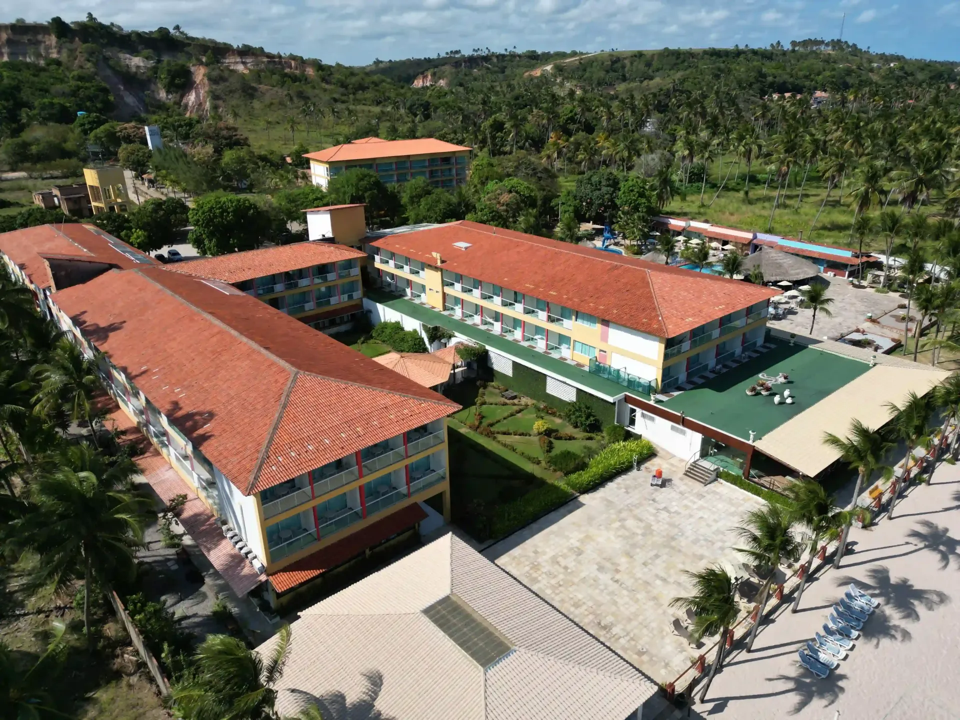 Uma vista aérea de um hotel cercado por palmeiras-hotel-praia-dourada-maragogi-park