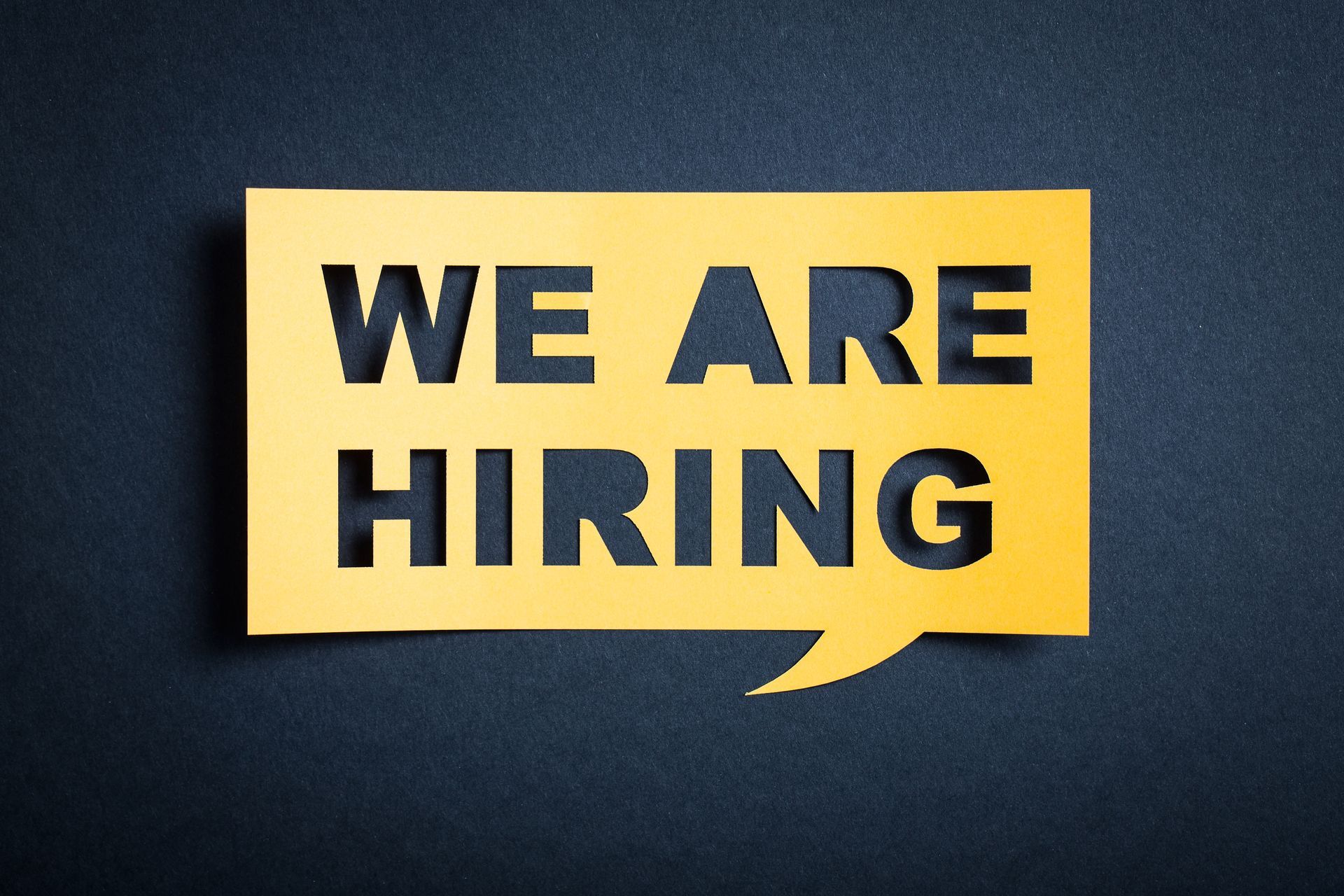 A yellow speech bubble on a dark blue background featuring the words