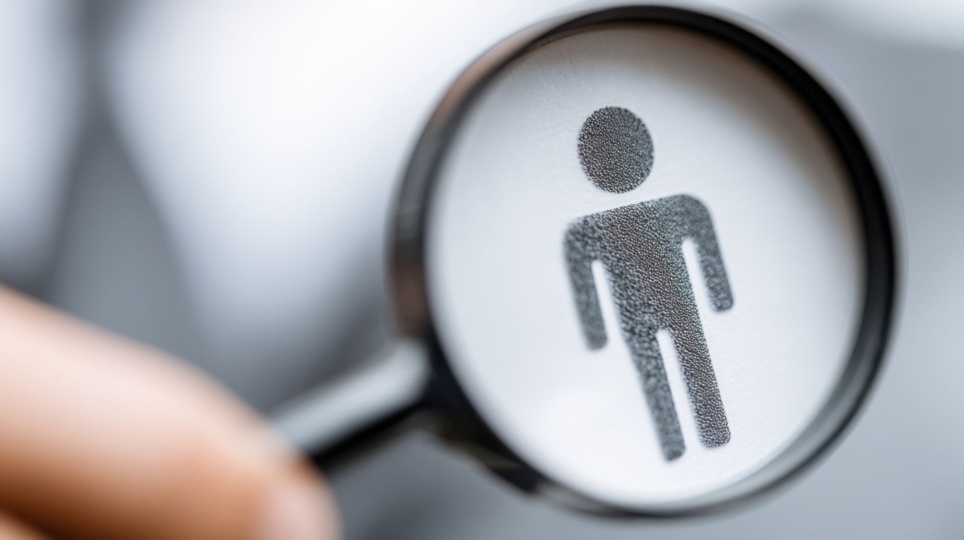 Magnifying glass over a person icon symbolizing recruitment and senior employment opportunities.