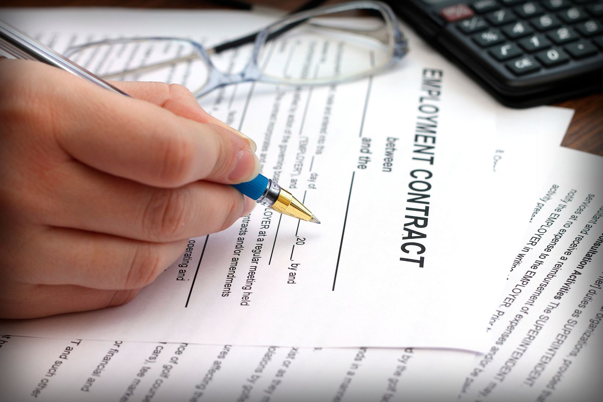Woman's hands signing an employment contract.