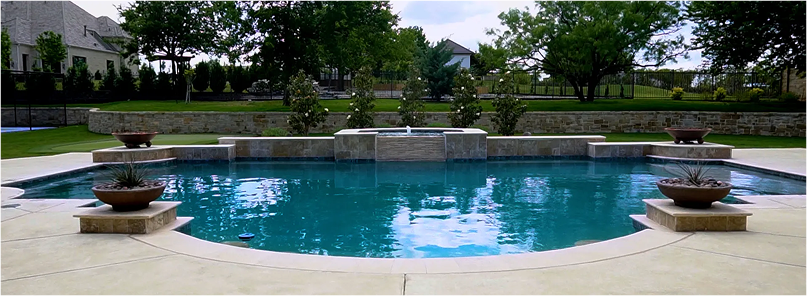 Fire pit with brown glass rocks, next to a pool with a blue surface.