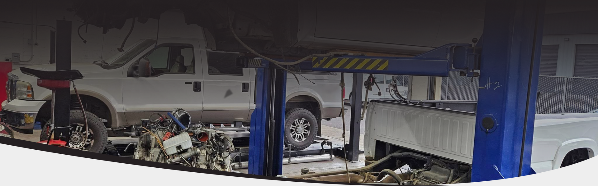 A car is sitting on a lift in a garage | Auto Team Service Center