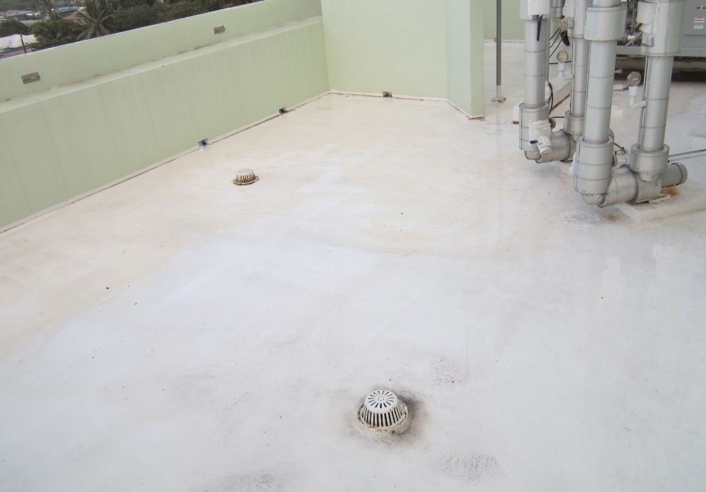 Flat white rooftop with vents, pipes, and a pale green parapet wall.