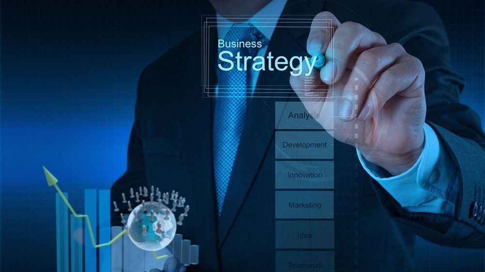 A man in a suit is writing the word strategy on a screen.