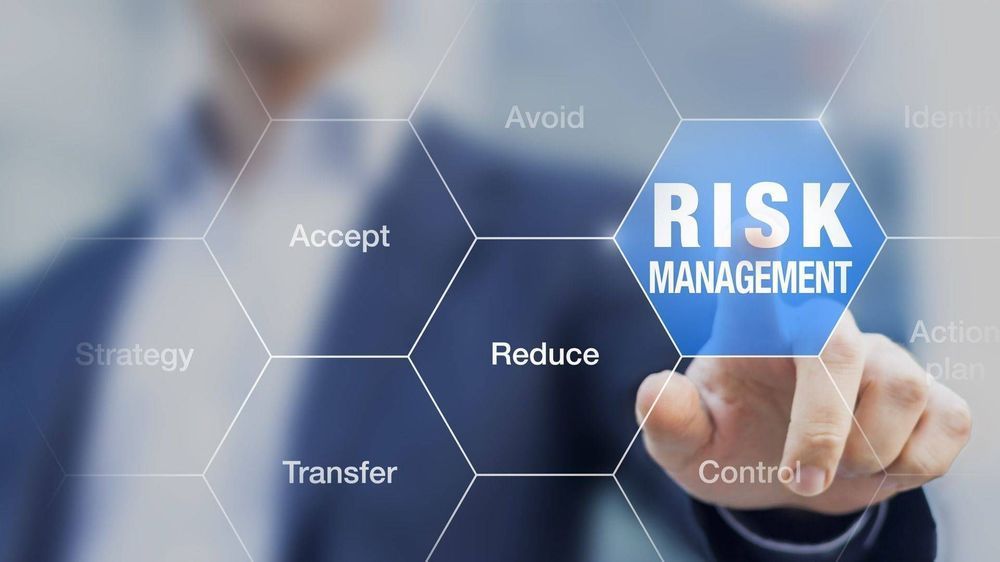 A man is pressing a button on a screen that says risk management.