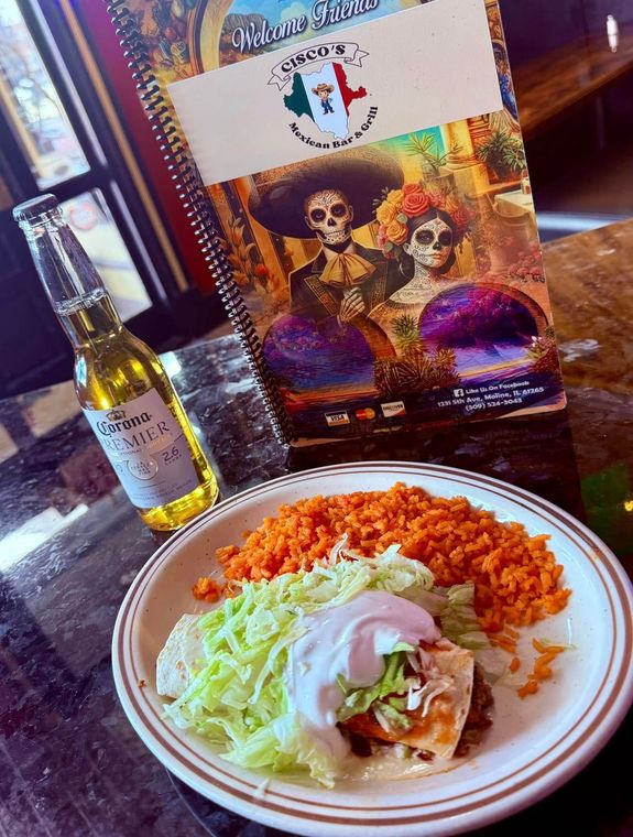 A plate of food next to a bottle of corona beer