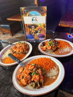 Three plates of food are sitting on a table next to a menu.