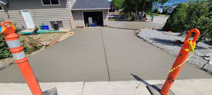 Freshly poured concrete driveway with orange safety cones.