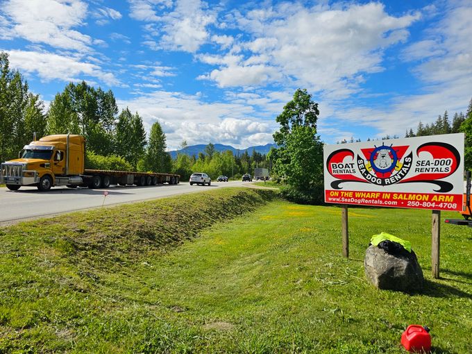 Yellow semi-truck on road, sign for 
