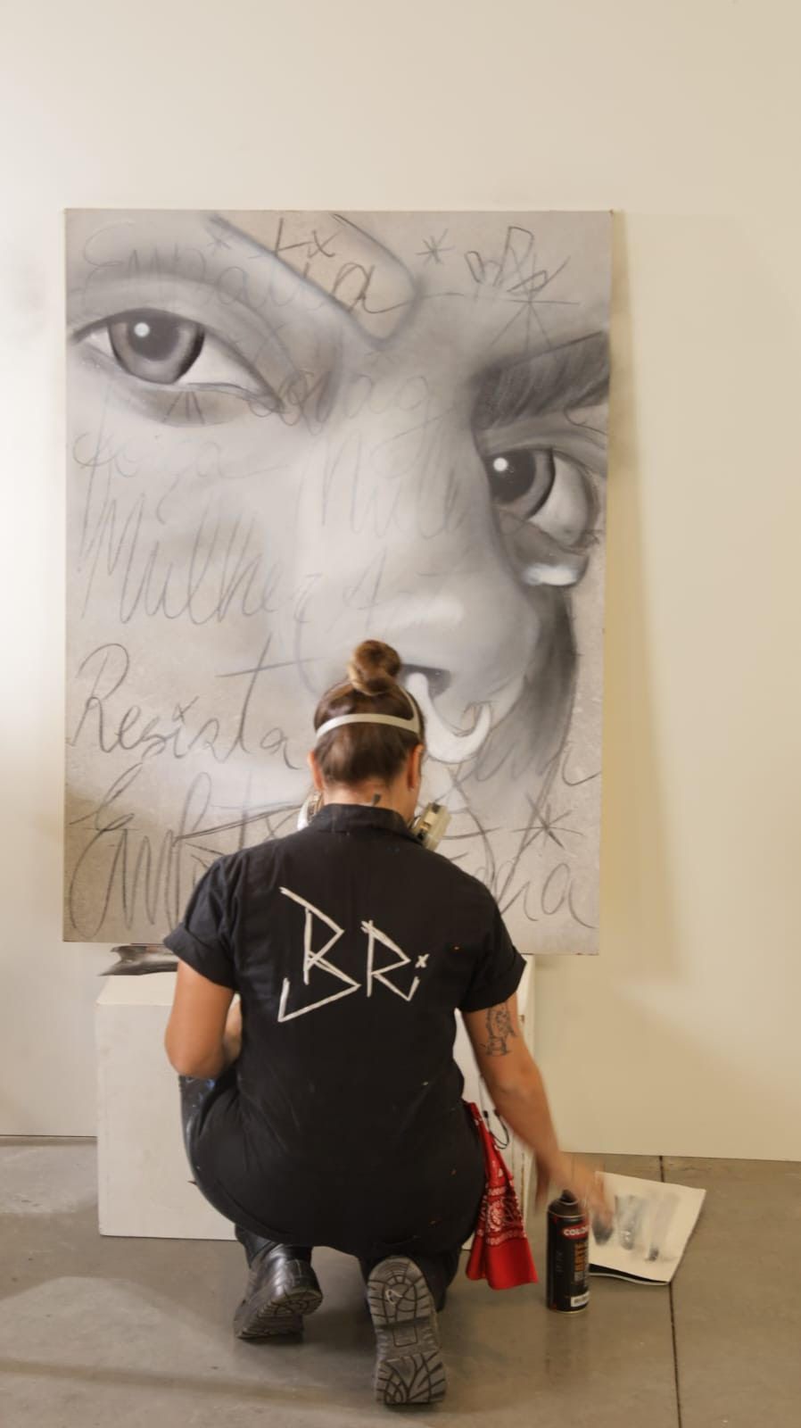 Artista pintando com spray em uma tela ao ar livre