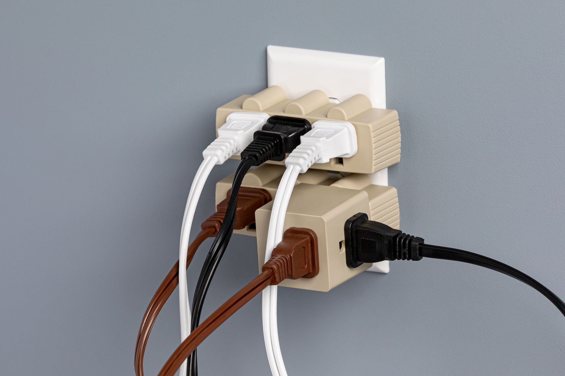 A bunch of plugs are plugged into a wall socket