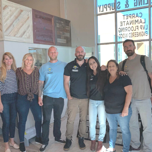 A group of people posing for a picture in front of a window that says yj99u2