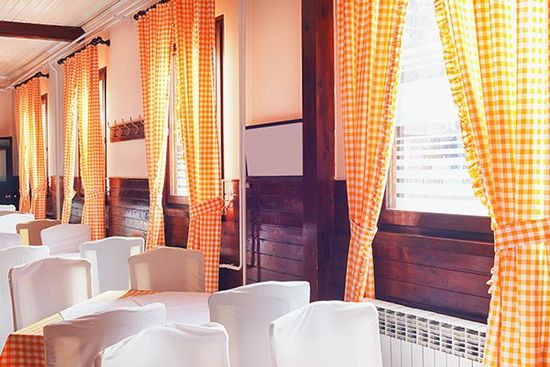 ristorante interno con tende in stile antico e mobili in bianco