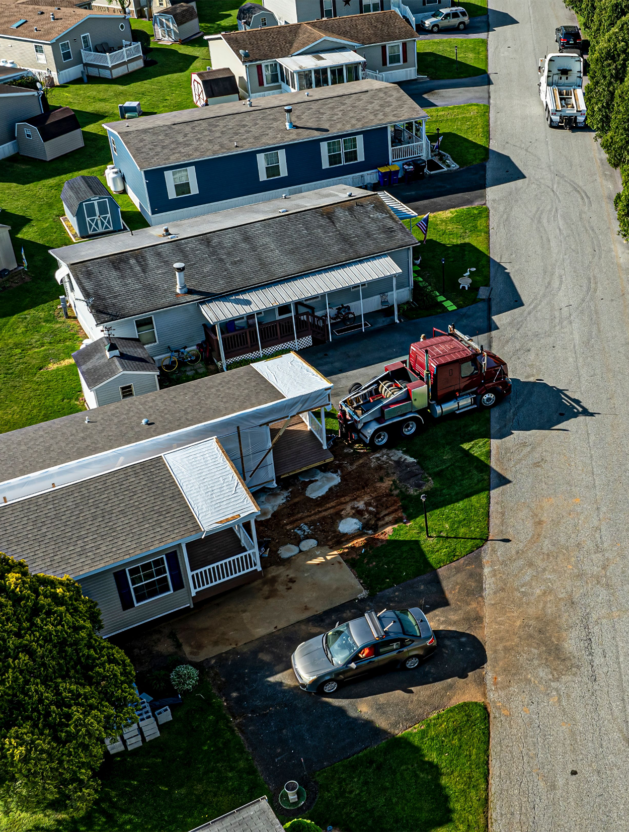 An aerial view of a residential area with houses and trucks