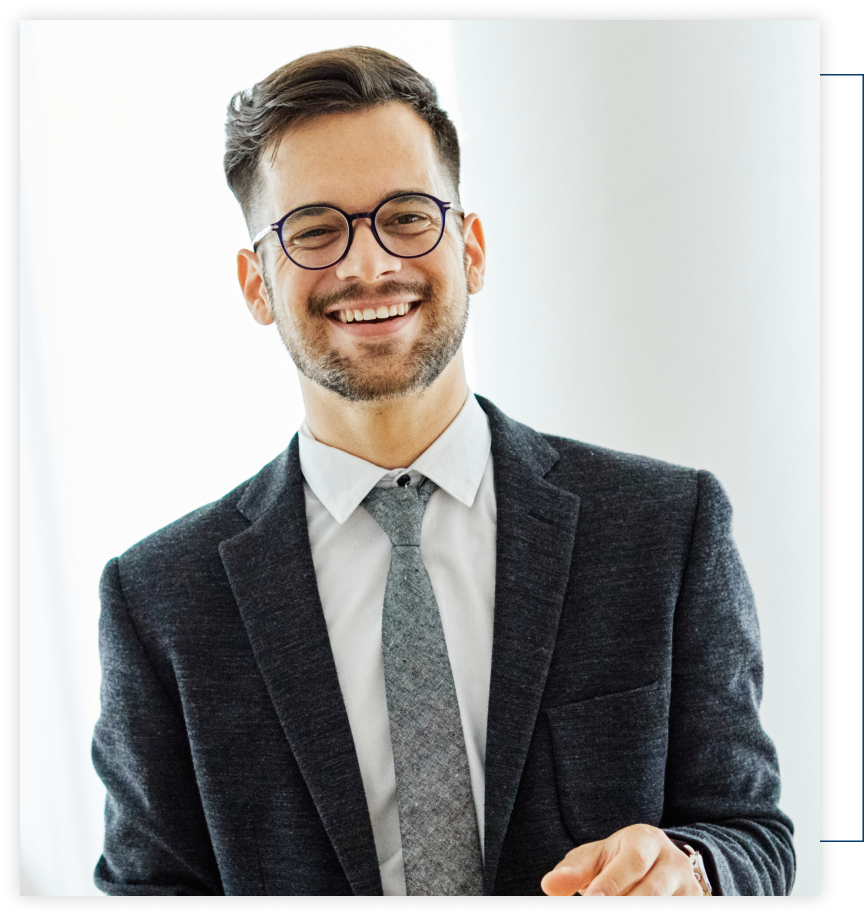 A man in a suit and tie is smiling for the camera