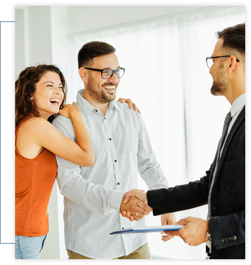 A man and woman are shaking hands with a man in a suit holding a clipboard.