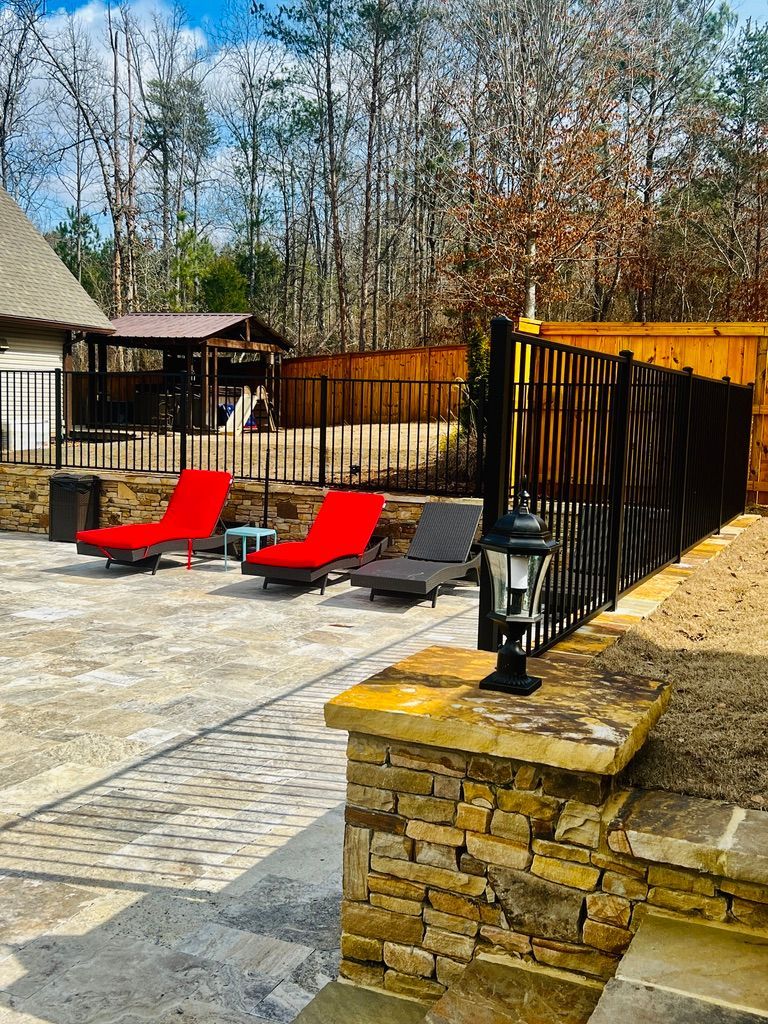 A patio with red chairs and a fence surrounding it.