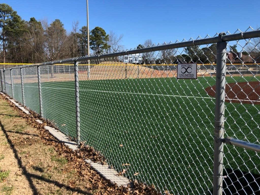 A chain link fence surrounds a baseball field.