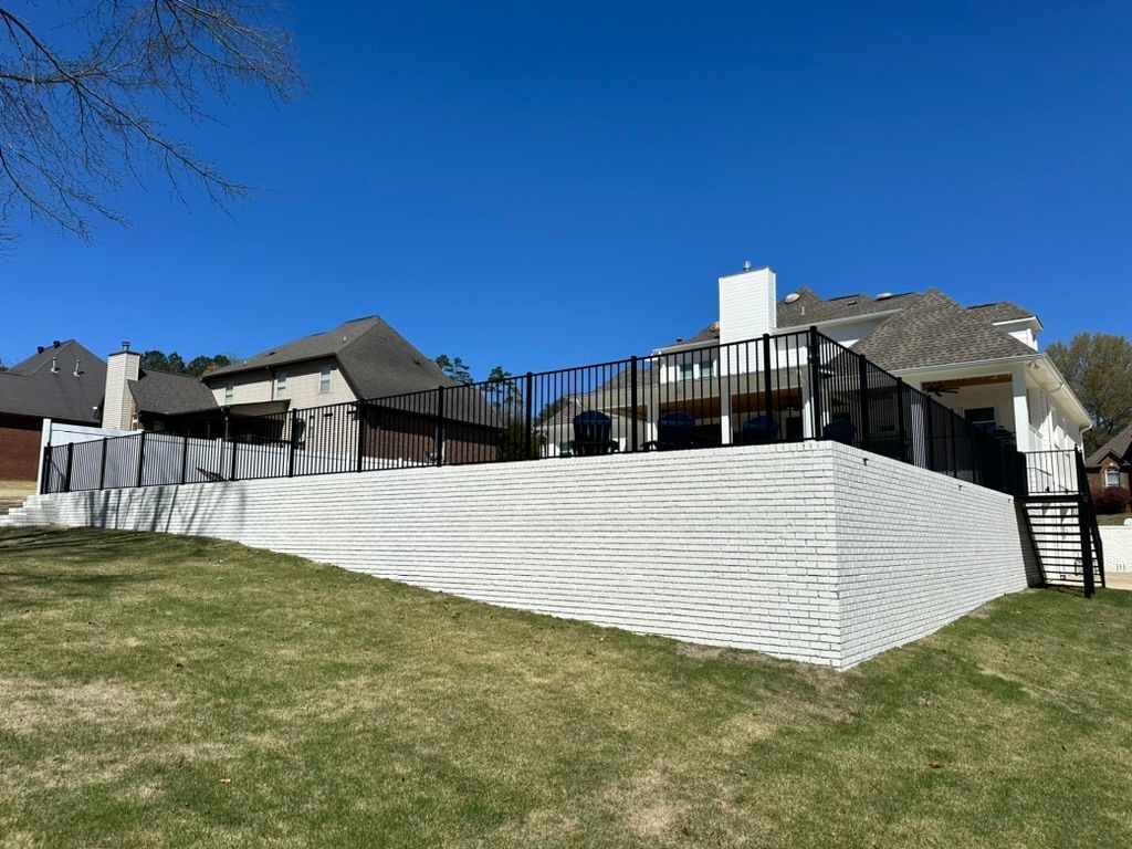 A large house with a large deck and stairs in the backyard.