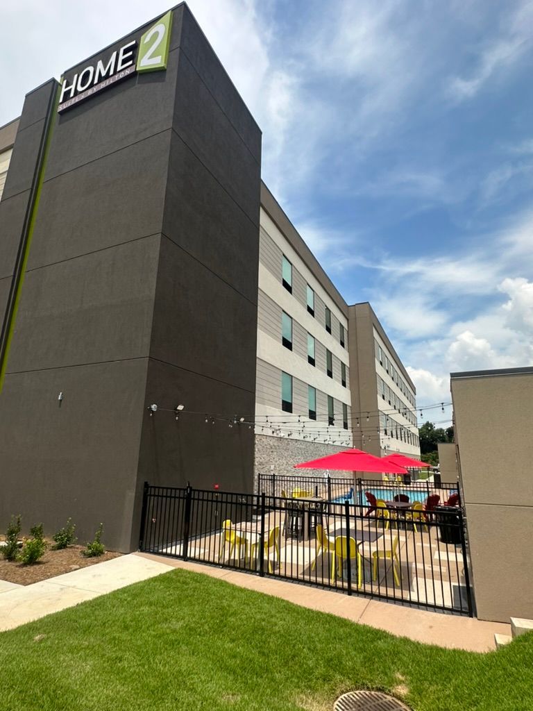 A large building with a pool and umbrellas in front of it.