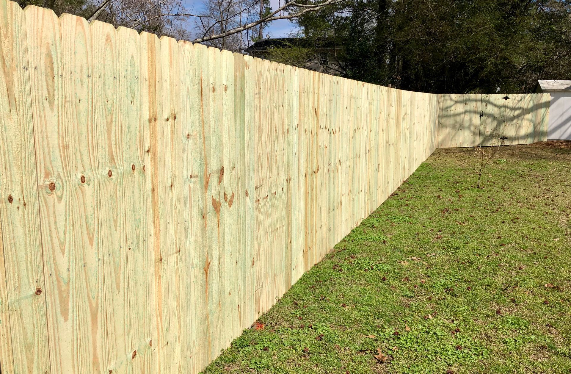 A wooden fence is sitting in the middle of a grassy yard.