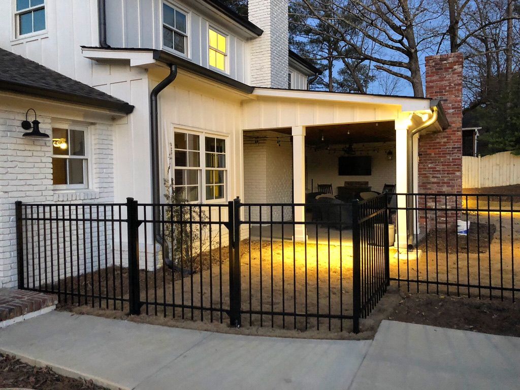 A white house with a black fence in front of it.