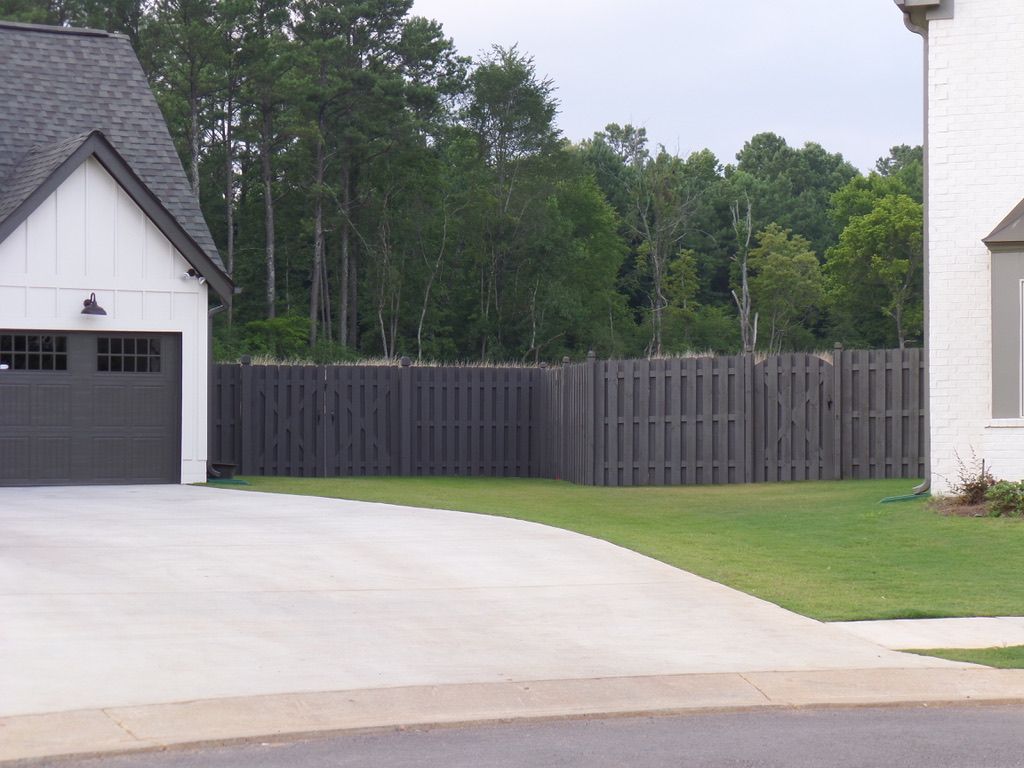 A white house with a garage and a wooden fence
