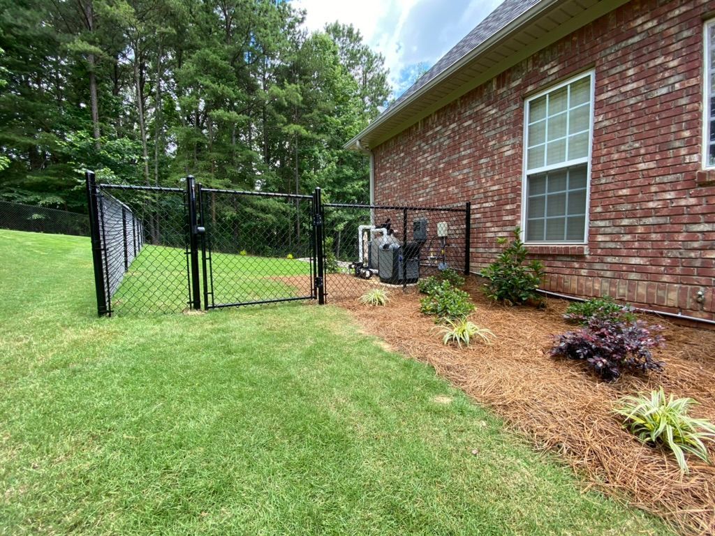 A brick house with a chain link fence in front of it.