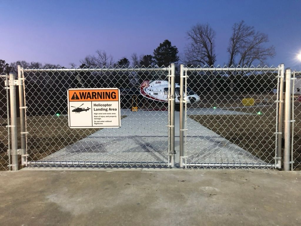 A chain link fence with a warning sign on it