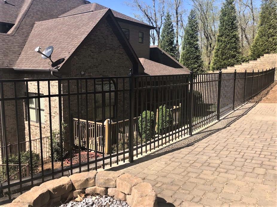 A house with a fence around it and a fire pit in front of it.