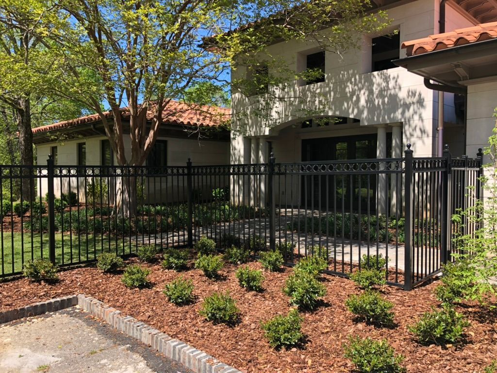 A large white house with a black fence in front of it.