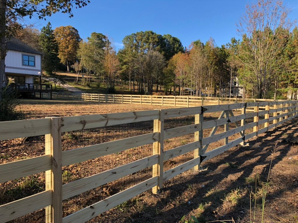 A wooden fence with a house in the background