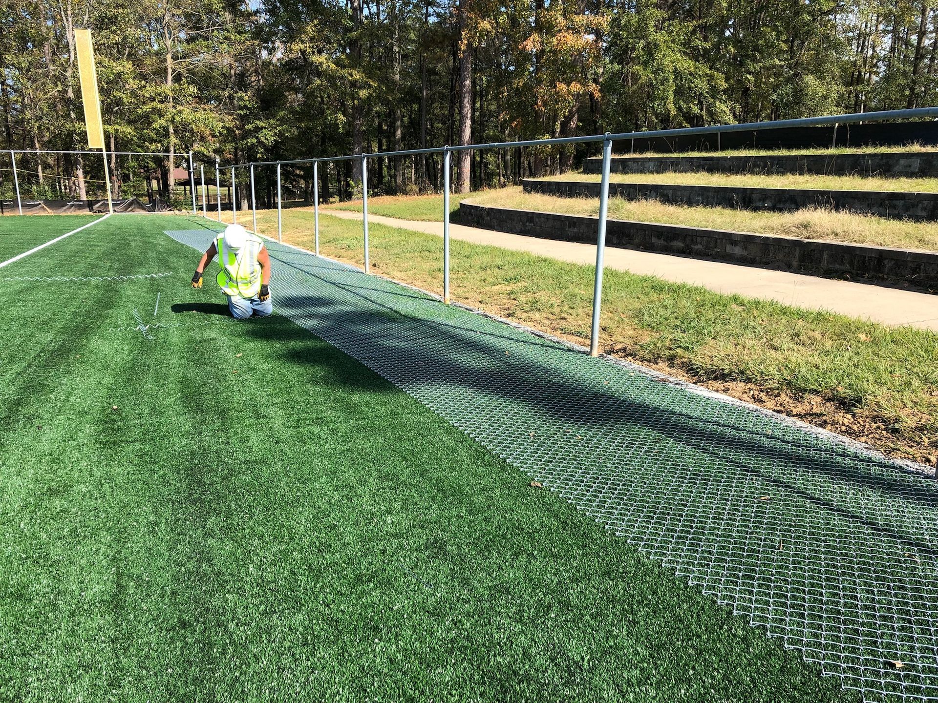 A person is standing on a soccer field holding a soccer ball.