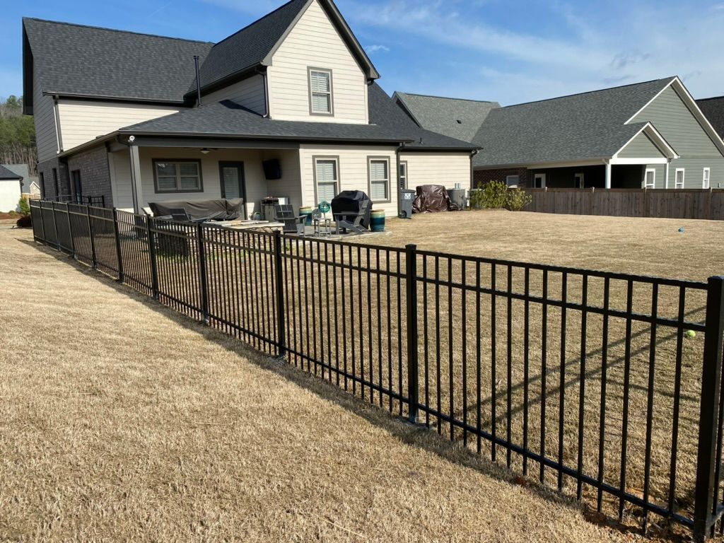 A house with a black fence in front of it.