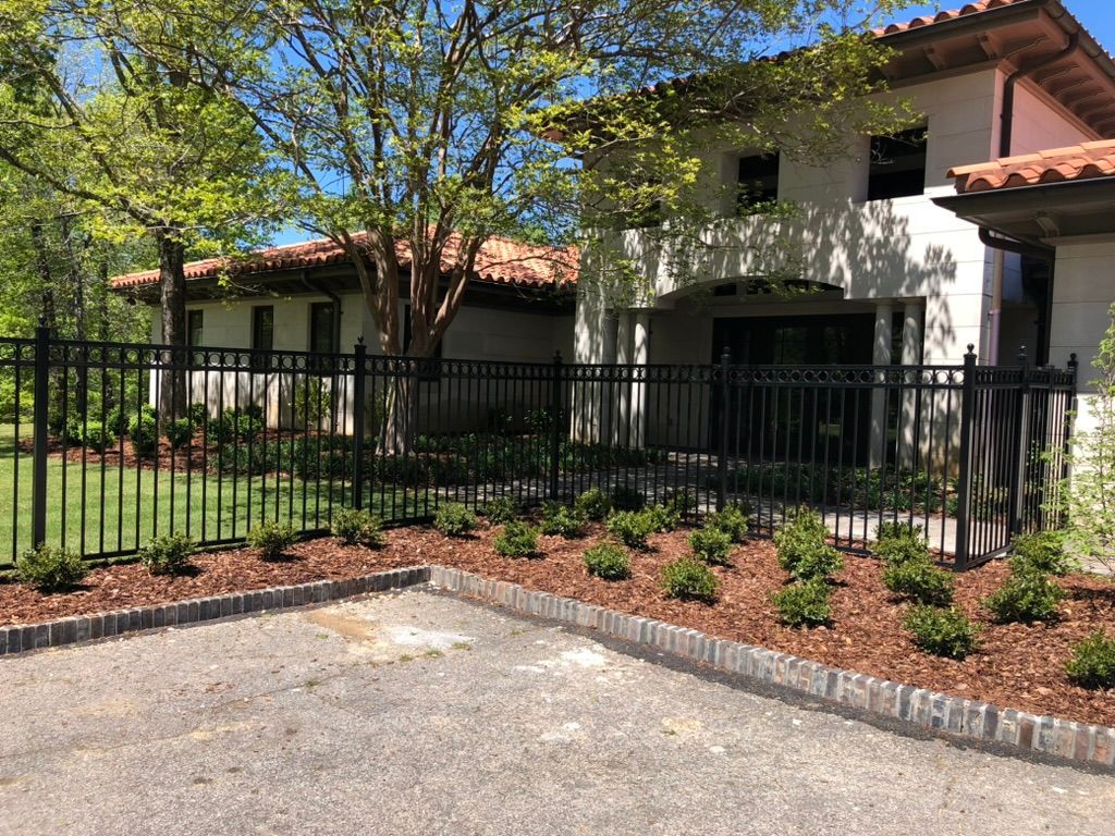 A large white house with a black fence in front of it.