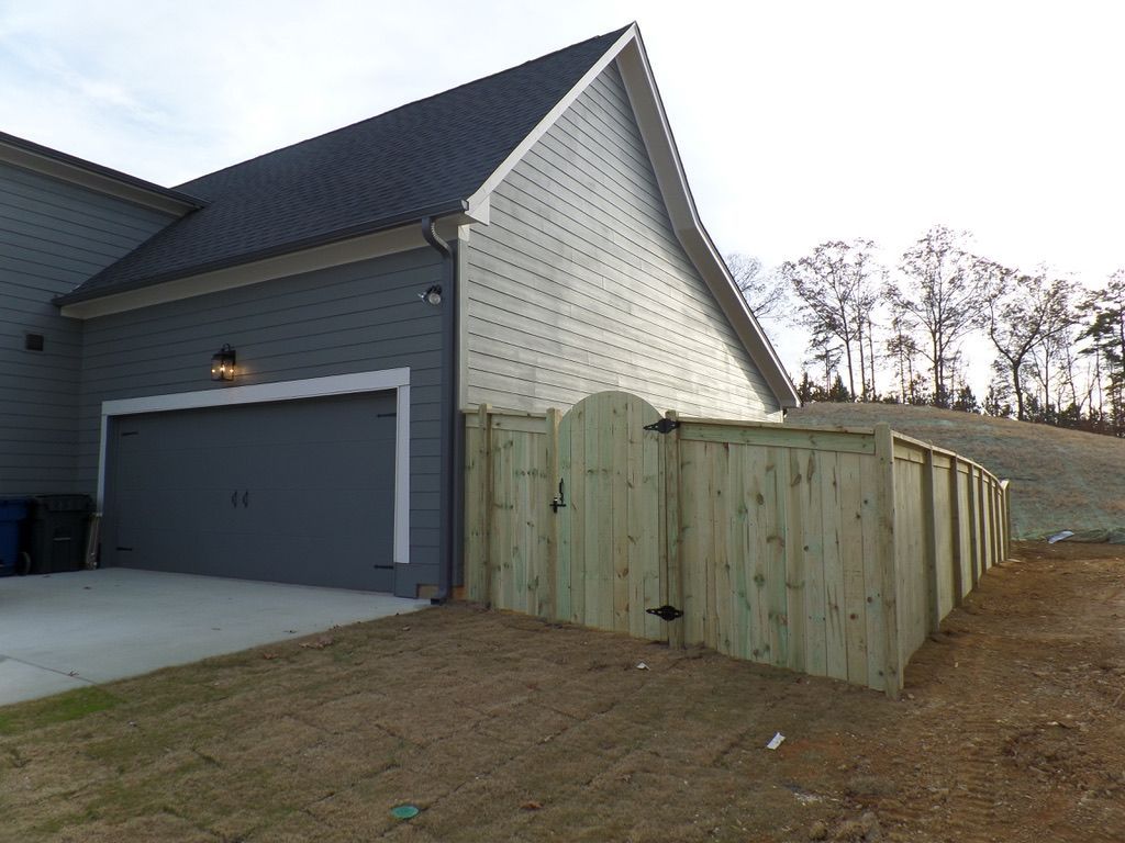 A garage with a wooden fence in front of it