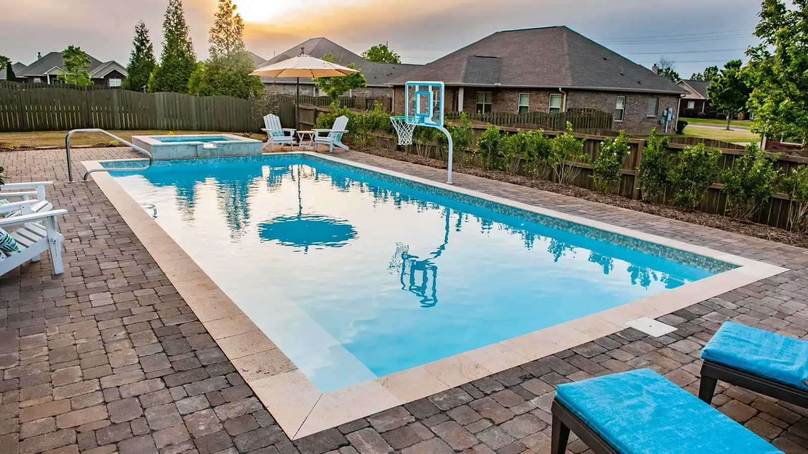 There is a large swimming pool in the backyard of a house.